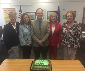 State Board of education standing over a cake