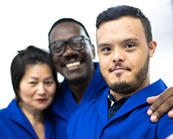 Image of young man with Down Syndrome with two adult counselors.