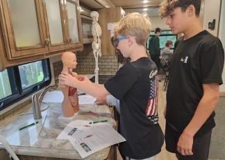 Students explore a human anatomy model during a recent visit from the Mobile Access to Possibilities (MAPs) vehicle. 